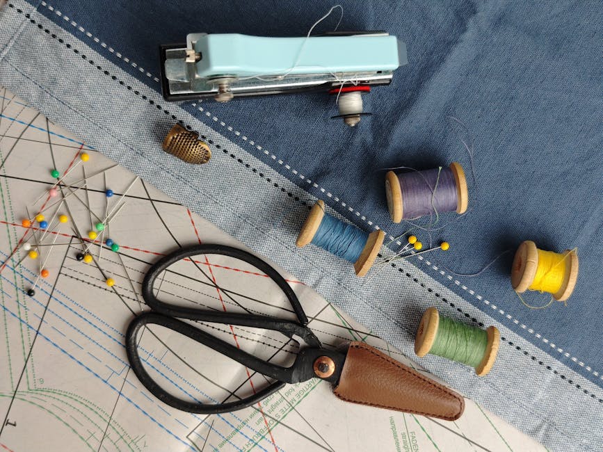 A flat lay of sewing supplies including threads, scissors, and a pattern on fabric.